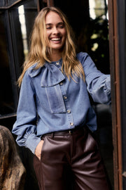 Blouse van denim met strikdetail in middenblauw door Tramontana, close-up van de stof en knoopdetails.