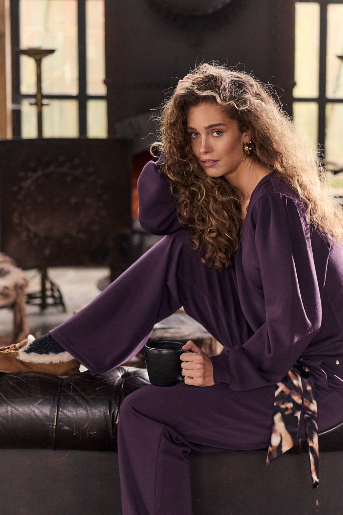 Aubergine en zwarte Tramontana broek en trui, met een bijpassende sjaal, getoond op een model.