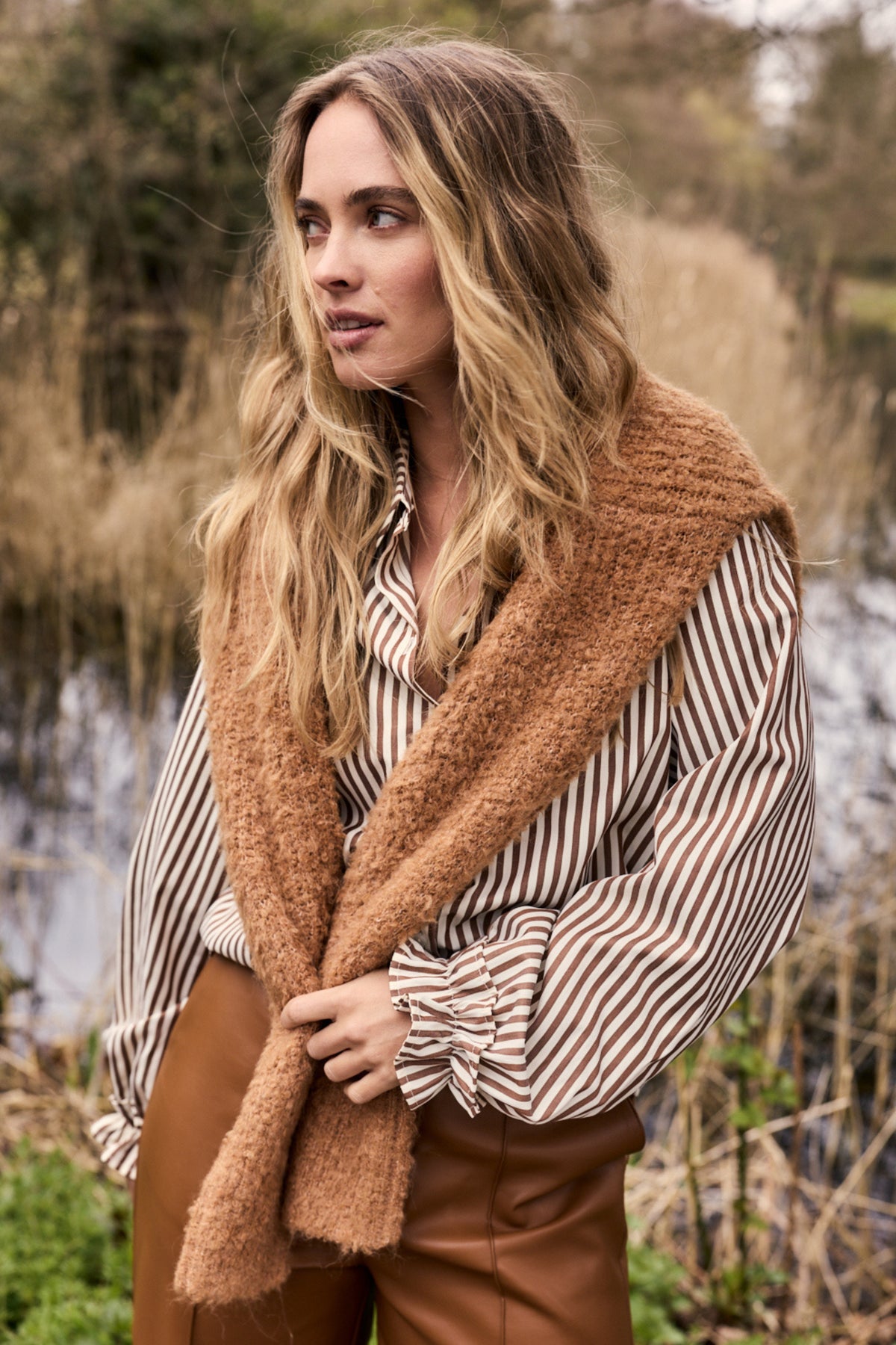 Blouse met strepen, ruffle manchetten en cinnamontint van Tramontana, getoond op een model met een neutrale achtergrond.