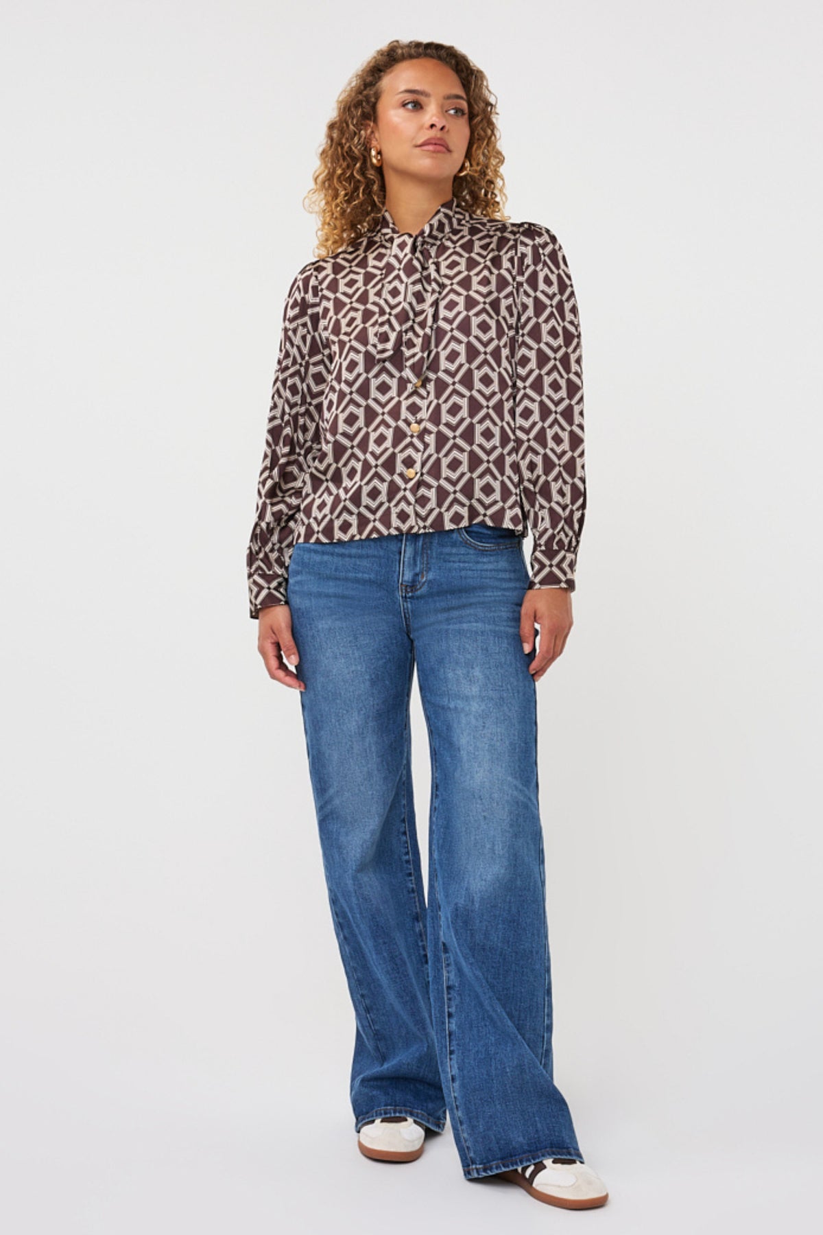 Witte blouse met korte pofmouwen en strik in de hals, met warm cacao print, van EsQualo, zichtbaar op de afbeelding.
