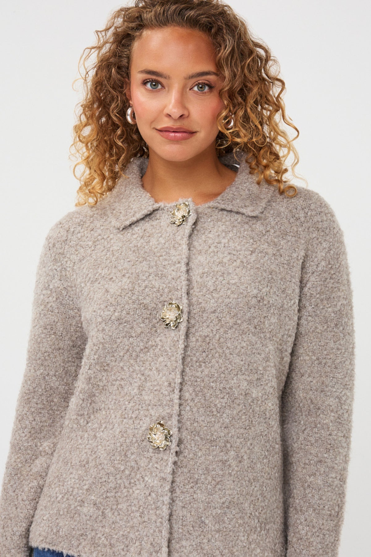 Grijze EsQualo cardigan met bloemenknopen en knopendetail, gedragen door een model, close-up van de stijlvolle damesmode.
