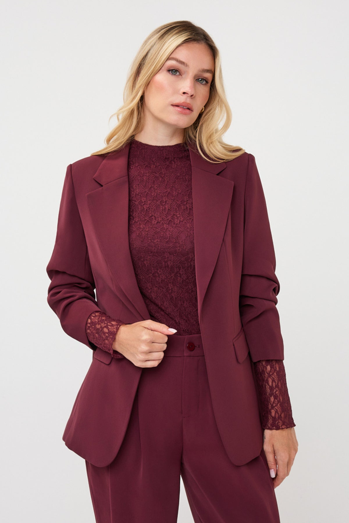 Zwart-blauwe blazer van EsQualo met fijne pasvorm en knopen, getoond op een model in een moderne binnenruimte.