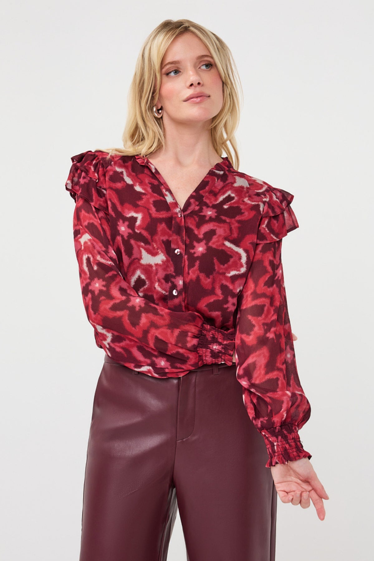 Blouse van EsQualo met ruffles en herfstbloemenprint, model Monique, zichtbaar in de afbeelding.