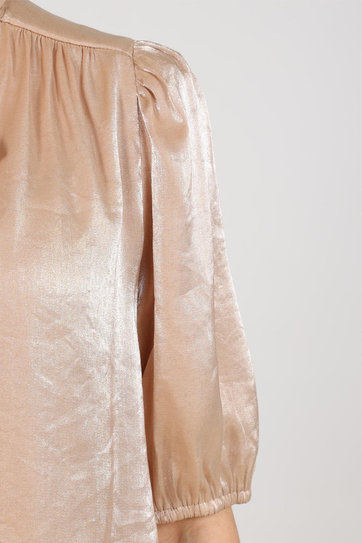 Nukus blouse Alberta Bow Sand met geknoopte details en losse pasvorm, zichtbaar in de afbeelding.