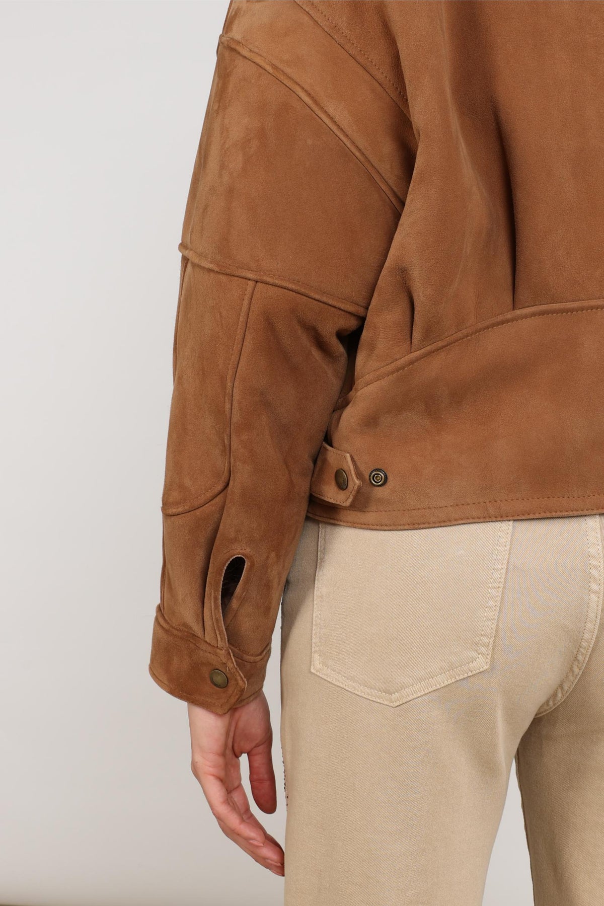 Nukus Evita Toffee Jas voor dames met dubbele knopen en stijlvolle details, gelegen op een houten vloer