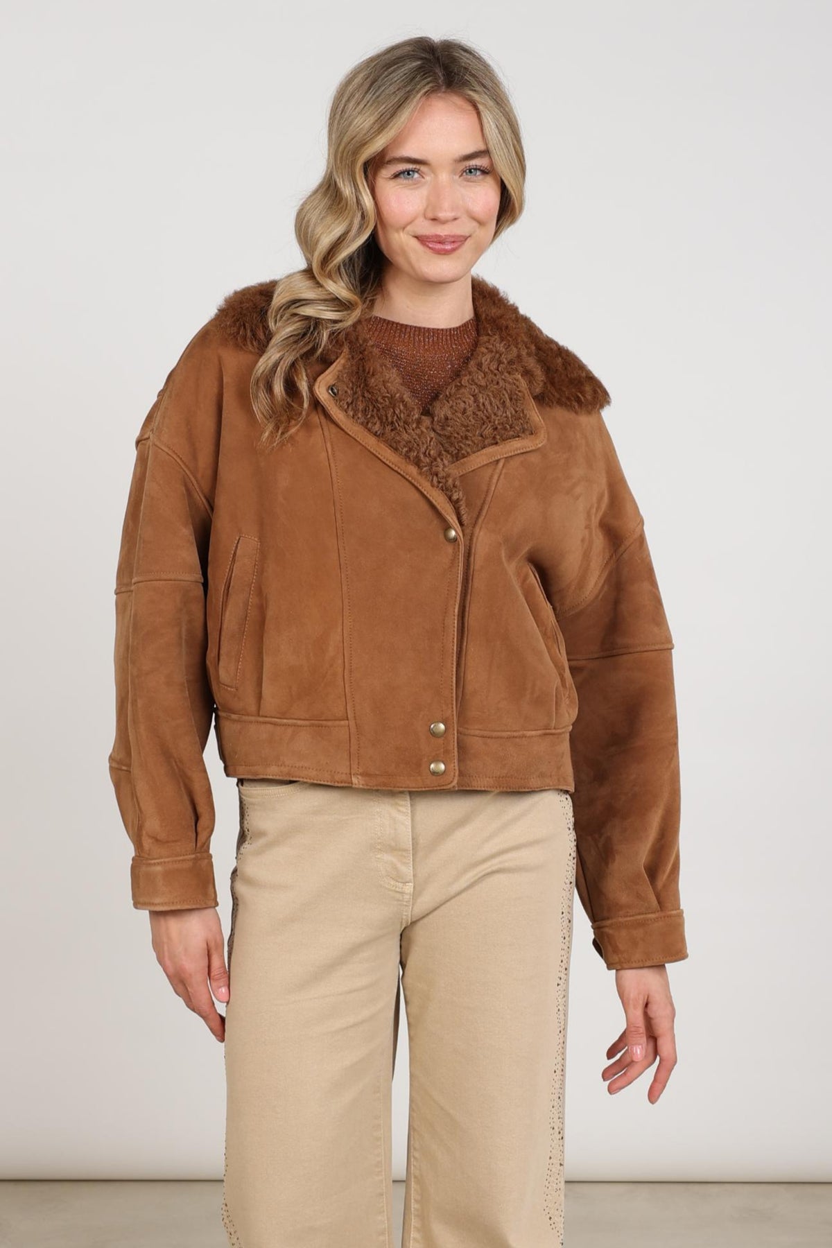 Lichte bruine Nukus Evita Toffee jas met ritssluiting en capuchon, gedragen door een model, voor dames.
