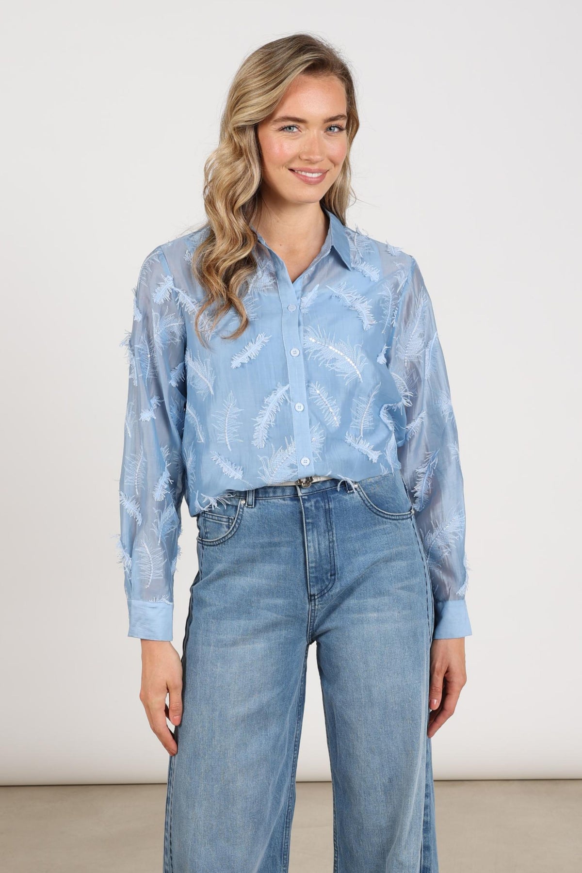 Lichte blauwe blouse Aysha met verenprint van Nukus, modieus en elegant voor dagelijks gebruik.