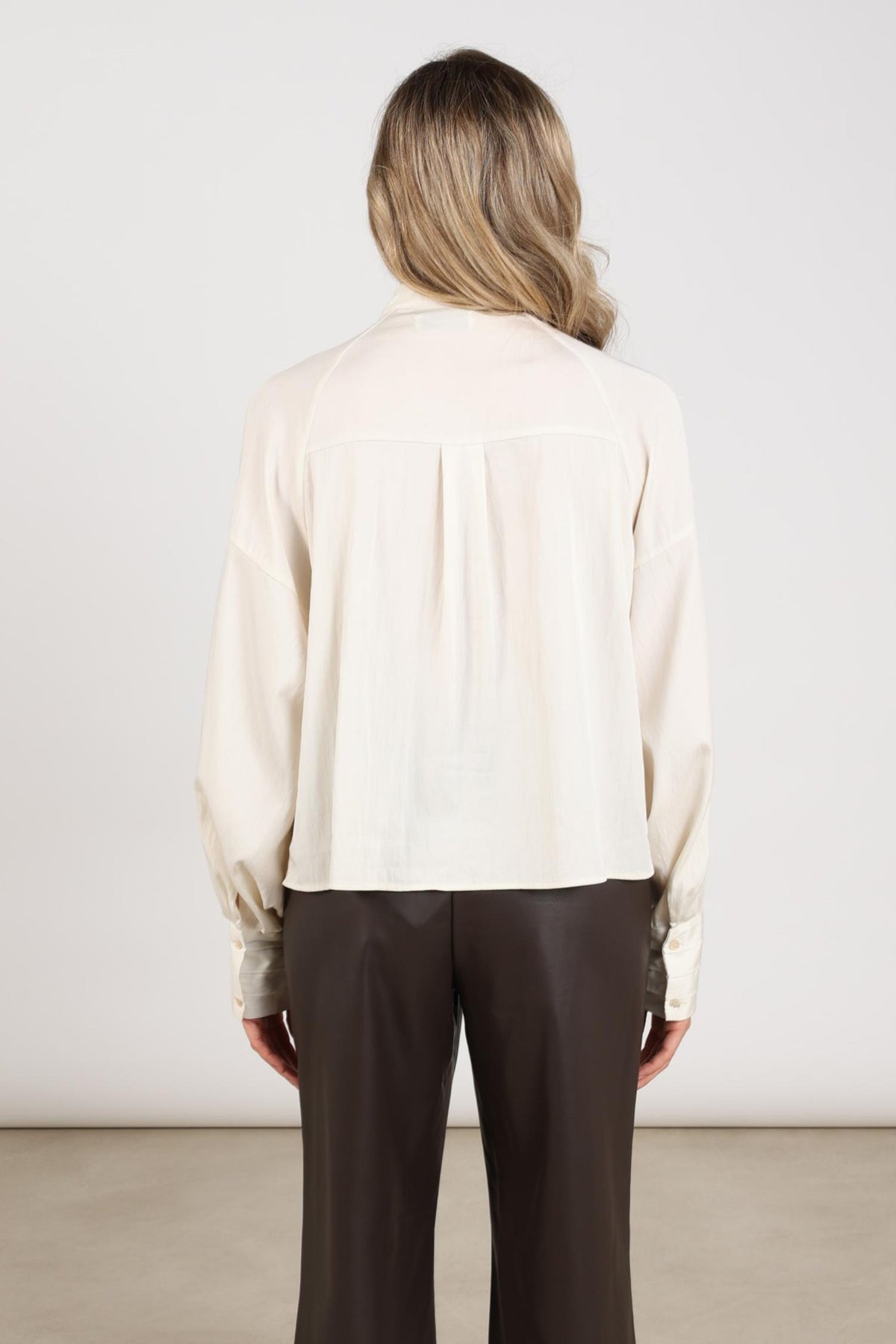 Offwhite blouse Alexandra van Nukus met lange mouwen en knoopsluiting, gedragen door een model.