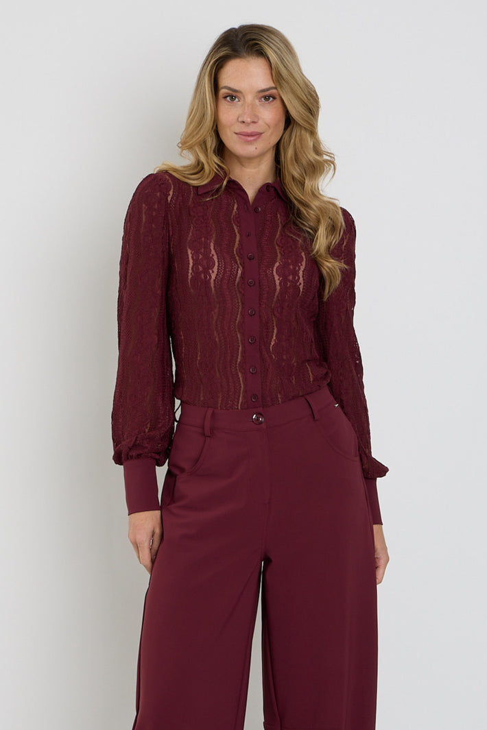 Burgundy travel blouse van Mi Piace met kantdetail, gedragen door een model, close-up van de stof en pasvorm.