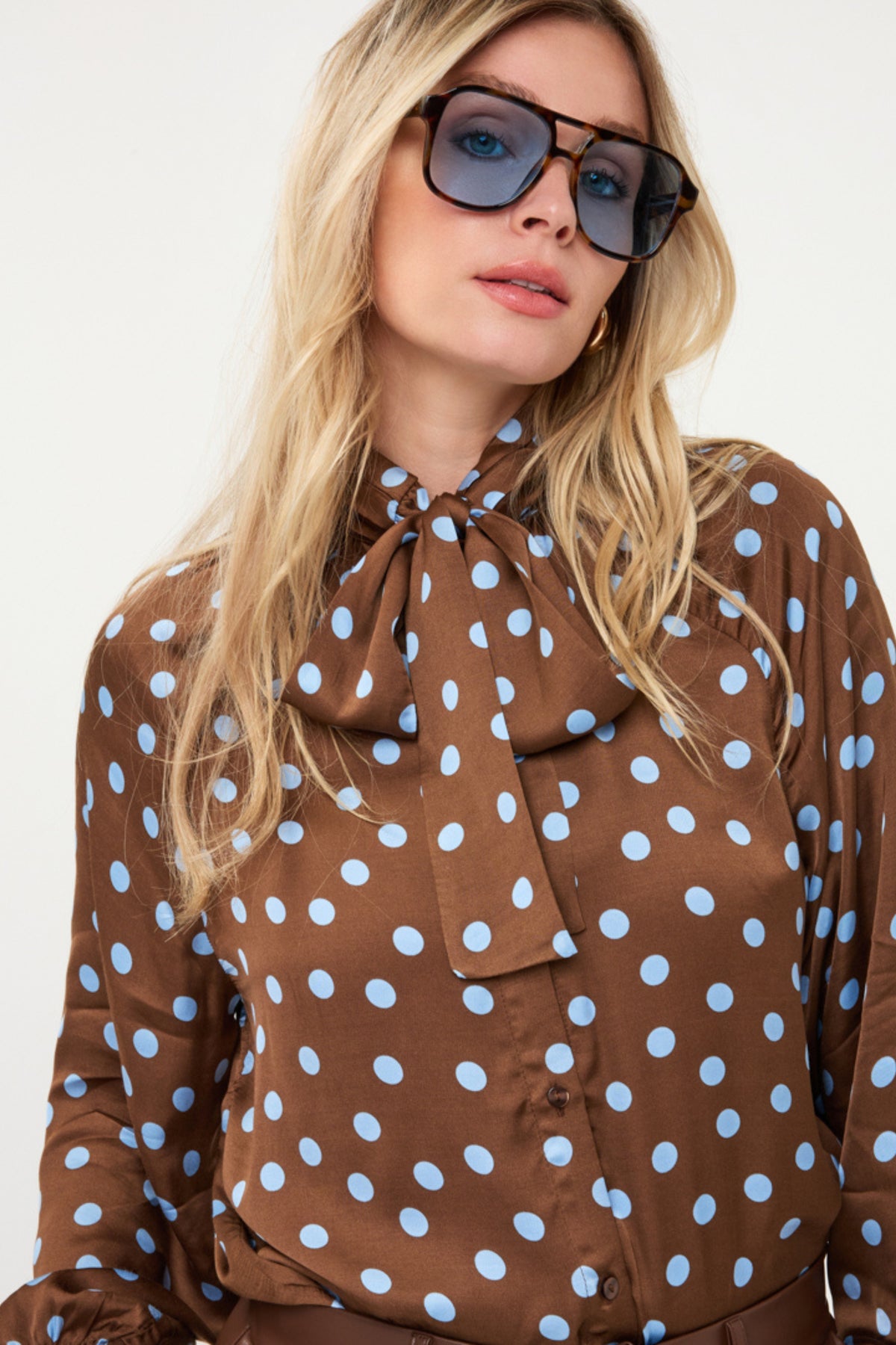 Zwarte blouse met polkadot print en sjaalkap, door EsQualo, gedragen door een model op de foto.