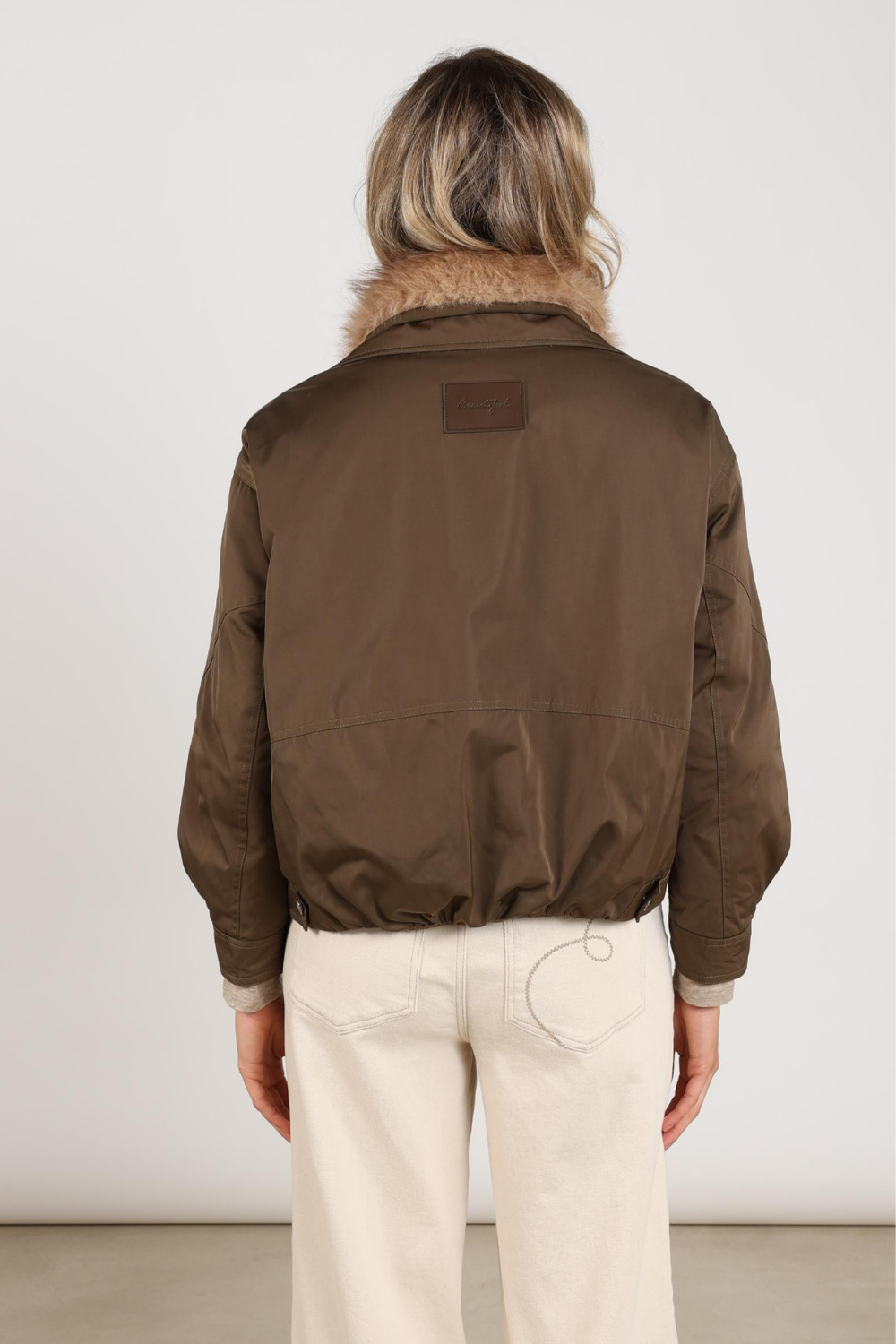Donkere Nukus Jacket Paula Moss NKF12013 met ritssluiting en capuchon, gedragen door een model op een witte achtergrond.