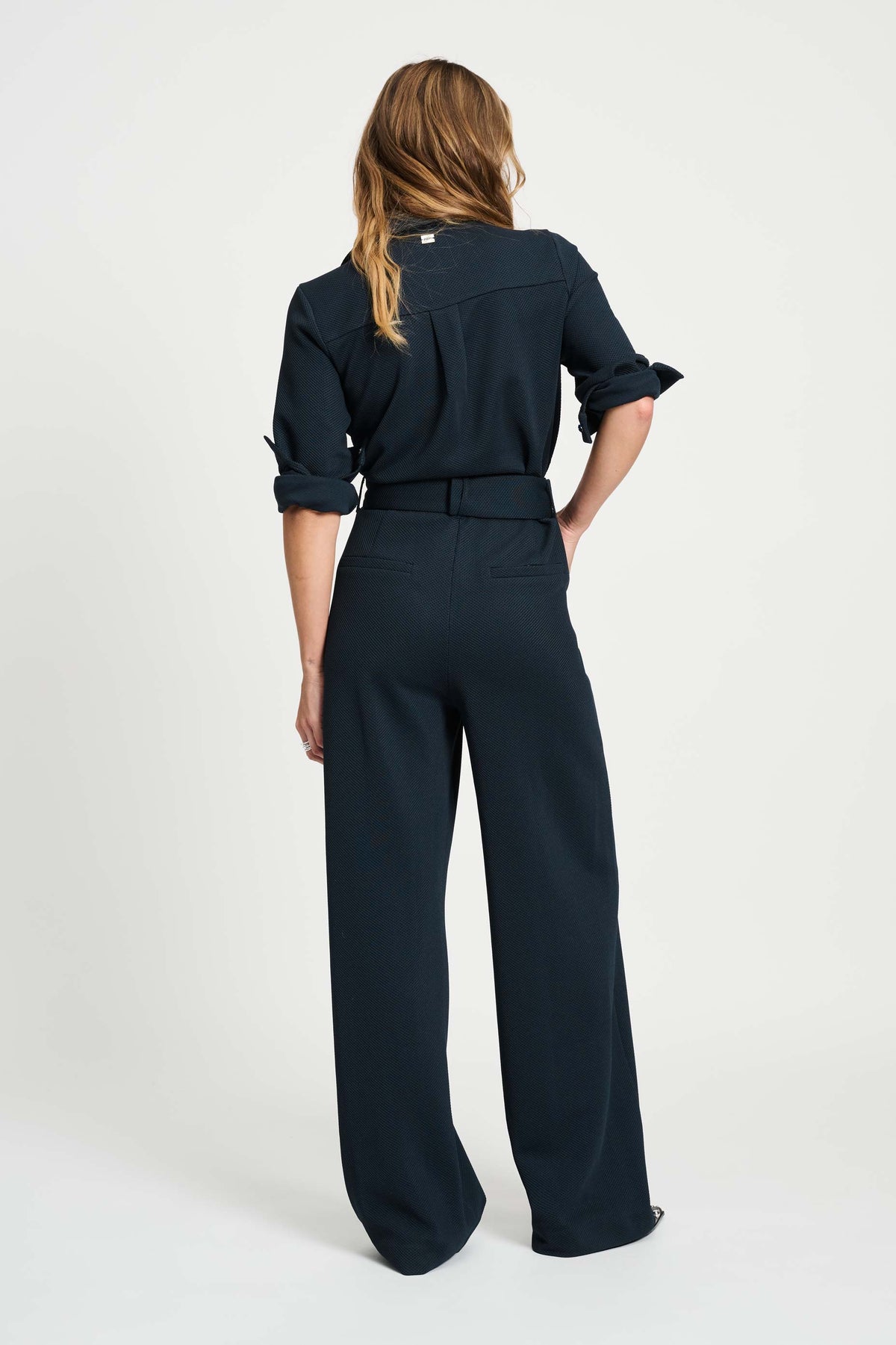 POM Amsterdam Megan jumpsuit in Eternal Blue, getailleerd model met lange mouwen en V-hals, gedragen door een model.