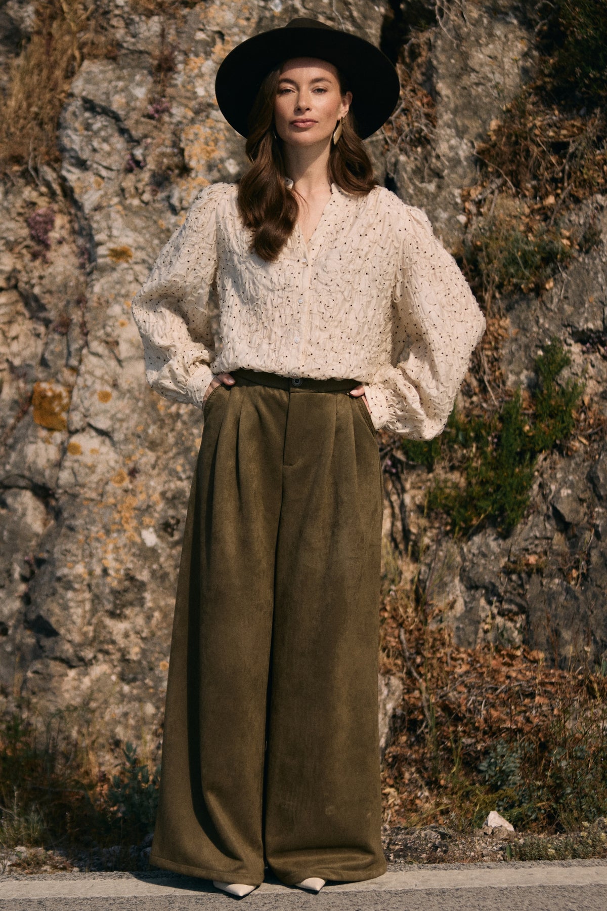 Suede broek Bodine Moss van Nukus, close-up van de zachte textuur en pasvorm op model, in een groene mosskleur.