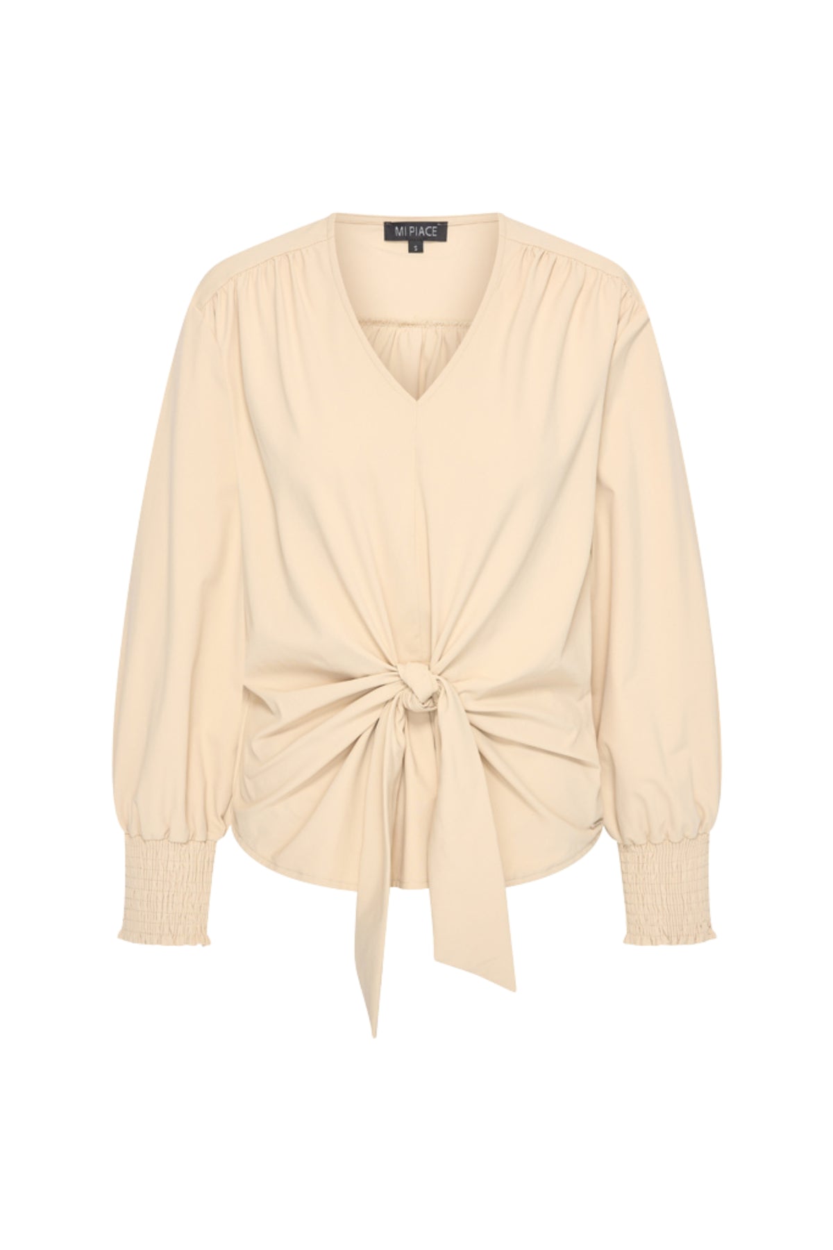 Mi Piace Travel Top Knotted Sand, lichtbruine top met knoopdetail, geschikt voor reizen en casual dragen.