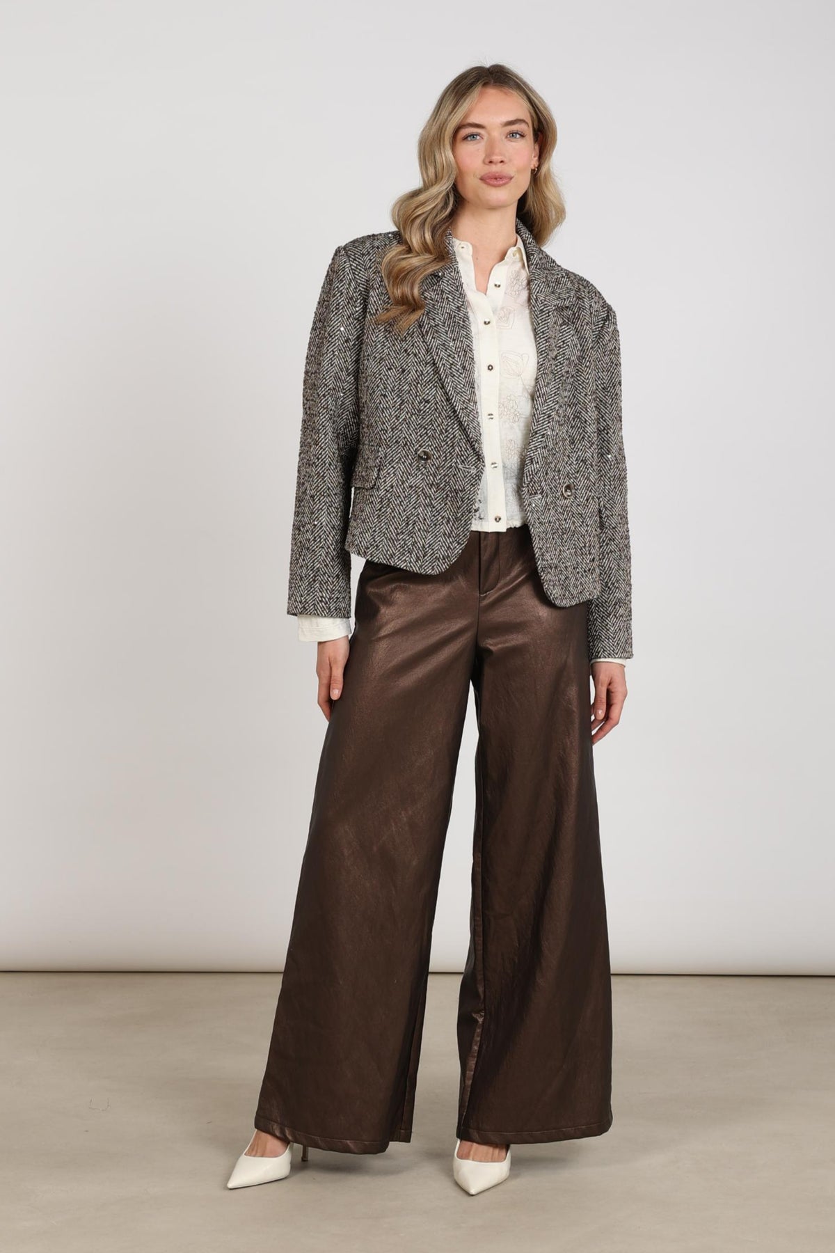 Donkere bruine Broek Bodine van Nukus met rechte snit en elastische taille, gedragen door een model op een witte achtergrond.