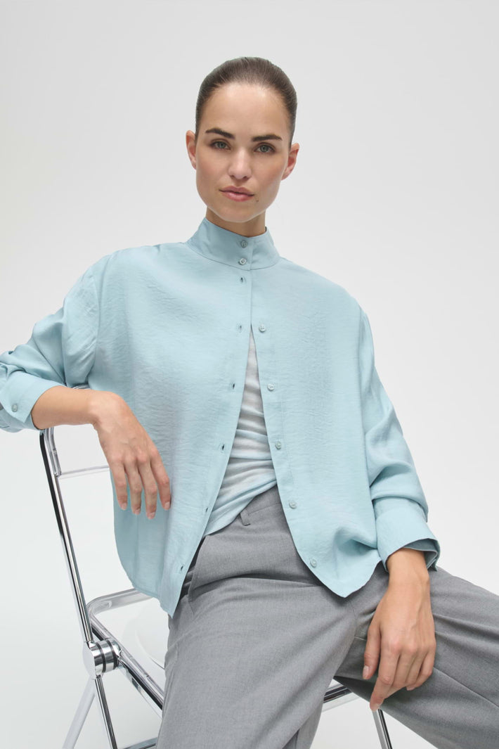 Blouse Fasofta Dusty Aqua van Opus, lichtblauwe blouse met ronde hals en lange mouwen, gedragen door een model.