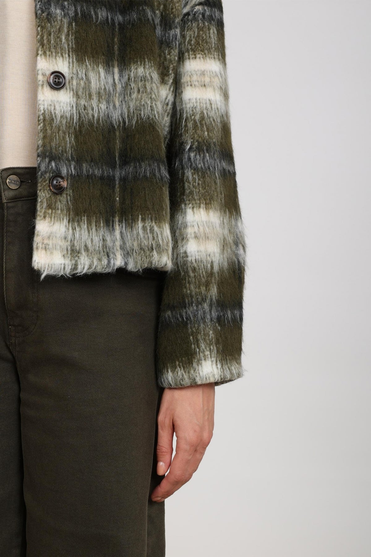 Lichte offwhite Nukus Debora jas met moss detail, getoond op een model, geschikt voor de herfst.