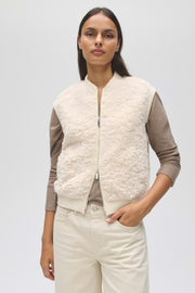 Licht crèmekleurige Opus Gilet Gaste Soft gedragen door een persoon, close-up van de zachte stof en stijlvolle pasvorm.