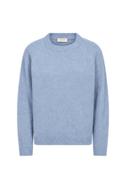 Lichte blauwe chambray trui van Freequent met zilveren details, gedragen door een model, close-up van de stof en pasvorm.