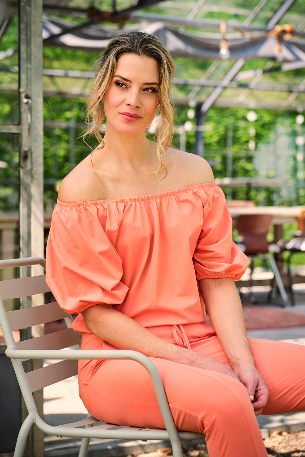 Zomerse travel top van Mi Piace in coral met Bardot-ontwerp, zichtbaar op de afbeelding.