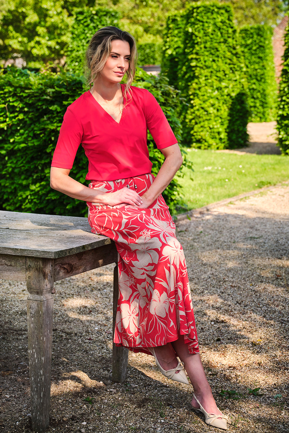 Roze rok met tropical hibiscusprint en rode details van het merk Mi Piace, geschikt voor zomerse gelegenheden.