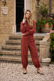 Gebruikte afbeelding van de Mi Piace Travel Balloon Bottom Bow broek in Fired Brick, met elastische tailleband en comfortabele pasvorm.