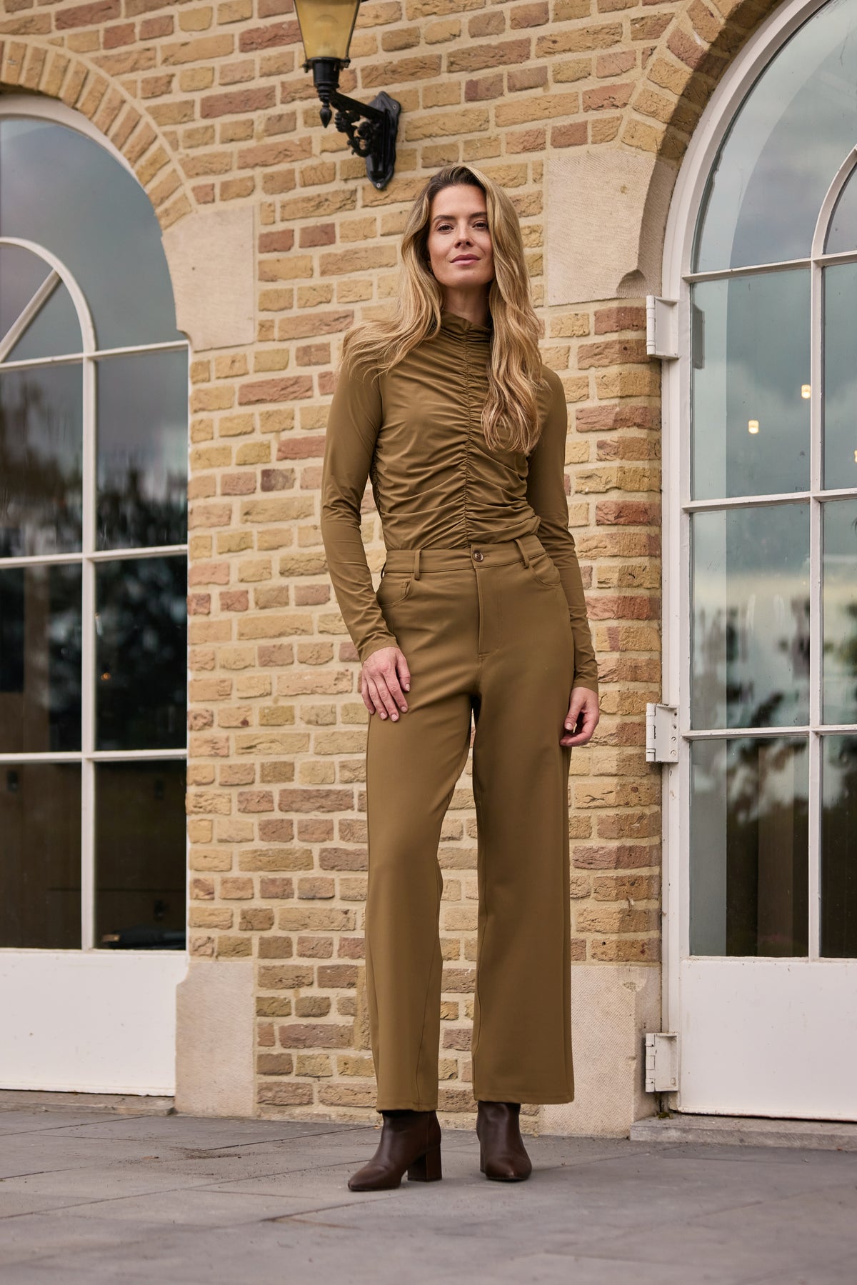 Lichte reis-top met wriefstructuur en kangaroe-ontwerp van Mi Piace, gedragen door een model op een neutrale achtergrond.