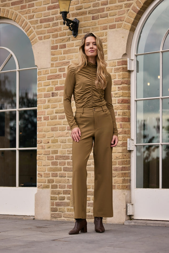 Lichte reis-top met wriefstructuur en kangaroe-ontwerp van Mi Piace, gedragen door een model op een neutrale achtergrond.