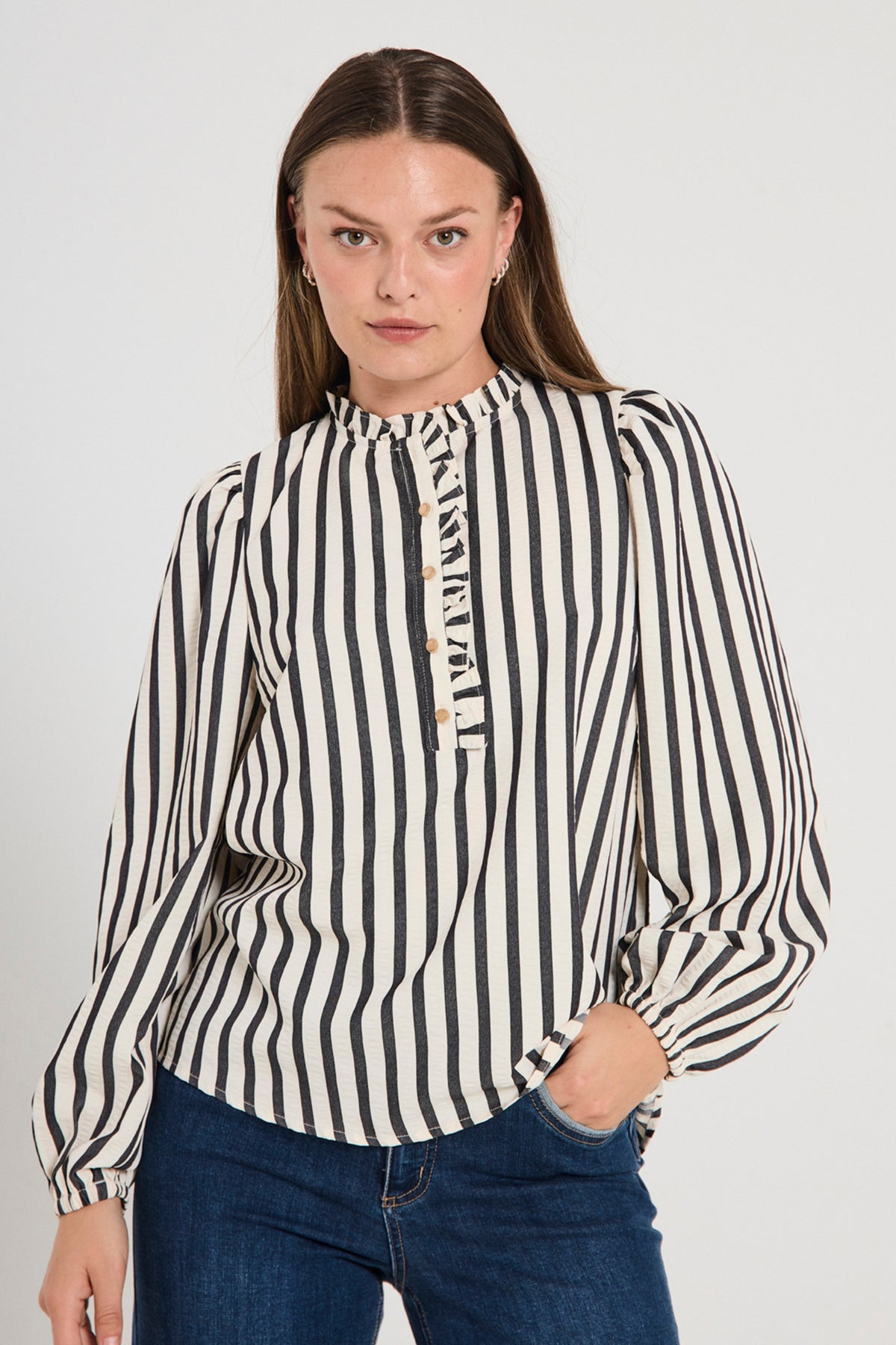 Offwhite en zwarte blouse van Freequent met sterdetail, getoond op een model met korte mouwen en losvallende pasvorm.