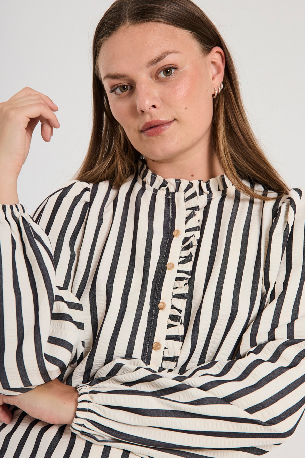 Offwhite en zwarte blouse van Freequent met sterpatroon, getoond op een model met lange mouwen en losse pasvorm.