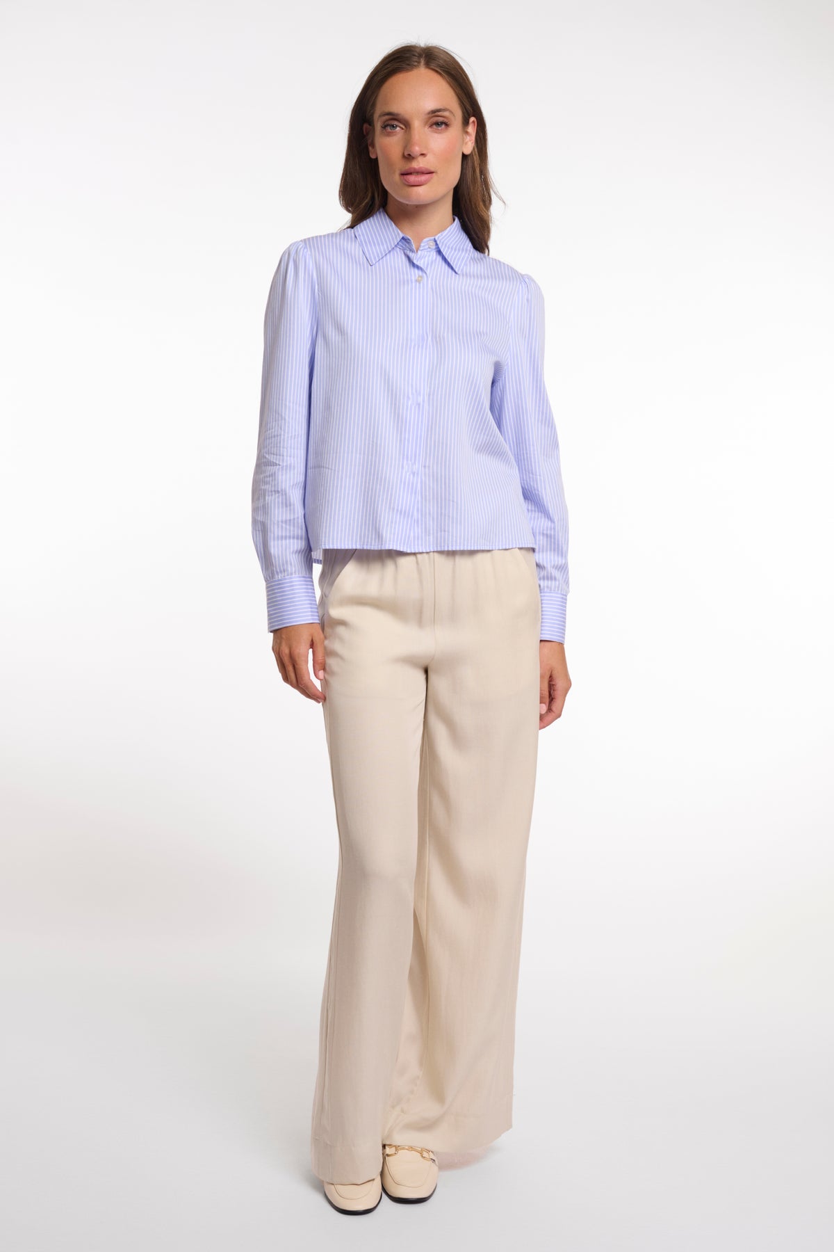 Blouse Felise van Rino & Pelle met blauwe strepen en lange mouwen, hangend aan een kapstok.
