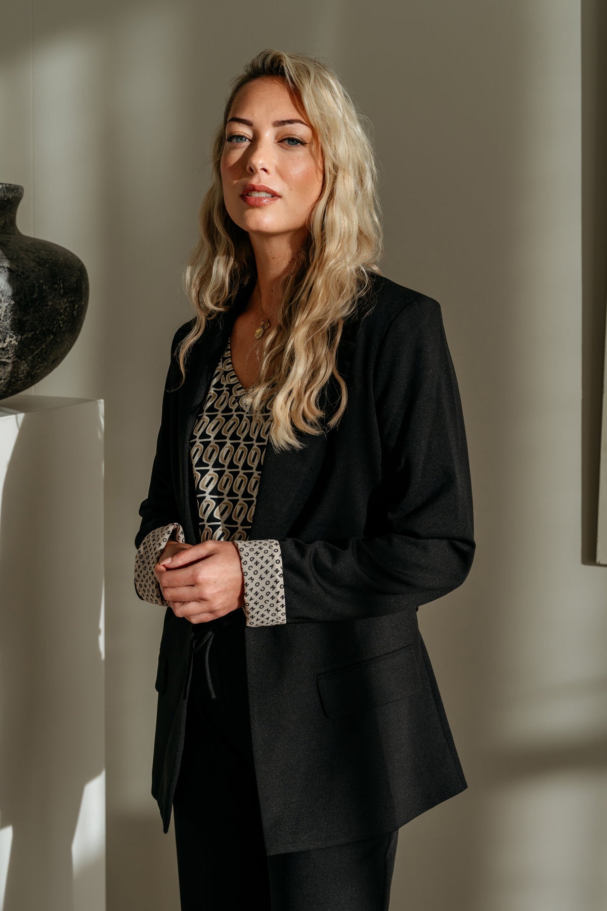 Marley Moon Sunset Top van &Co woman, kleurrijk gelaagd ontwerp, gedragen door een model, close-up van de stof en details.