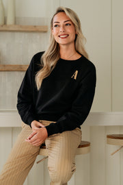 Zwarte trui van &Co woman met een losse pasvorm en lange mouwen, getoond op een model.
