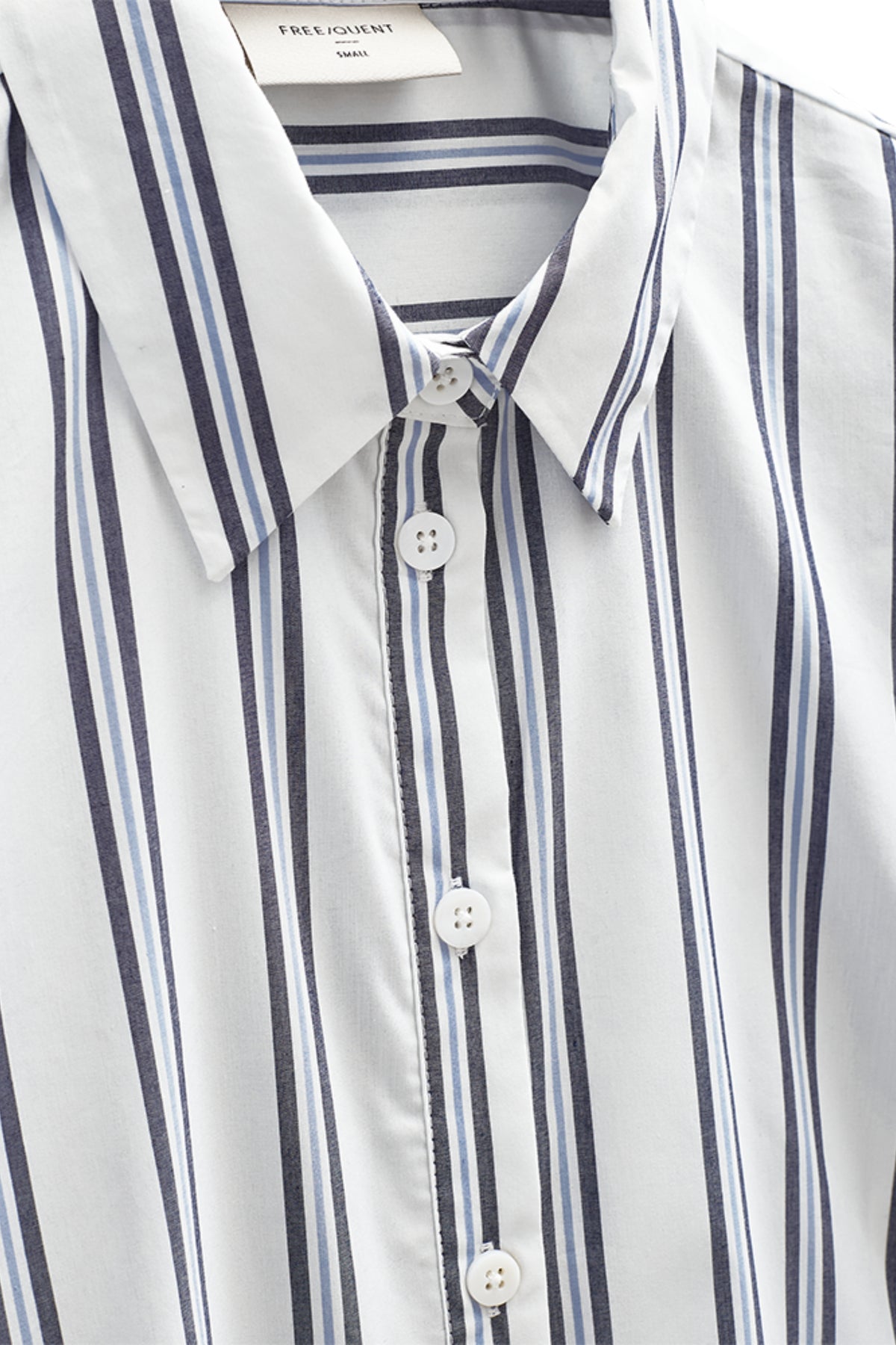 Lichte offwhite blouse met sterdetails van Freequent, gecombineerd met een navy blazer, gedragen door een model.