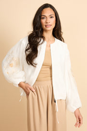 Lichte offwhite G-maxx Zaira jas met ritssluiting en capuchon, gedragen door een model op een neutrale achtergrond