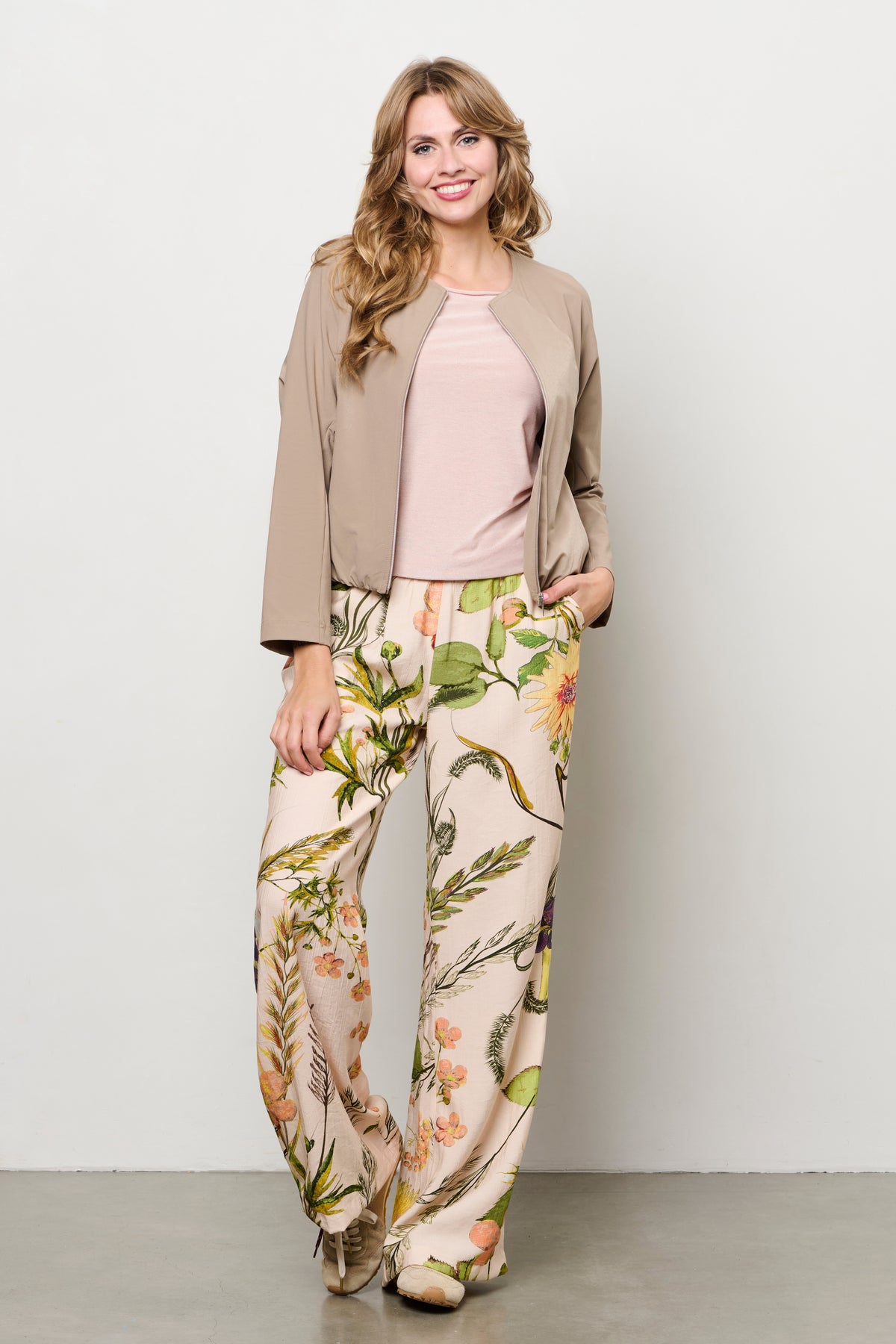 Roze multicolor bloempatroon broek Nadine Flower van &Co woman, vloeiend en modieus, gedragen door een model.