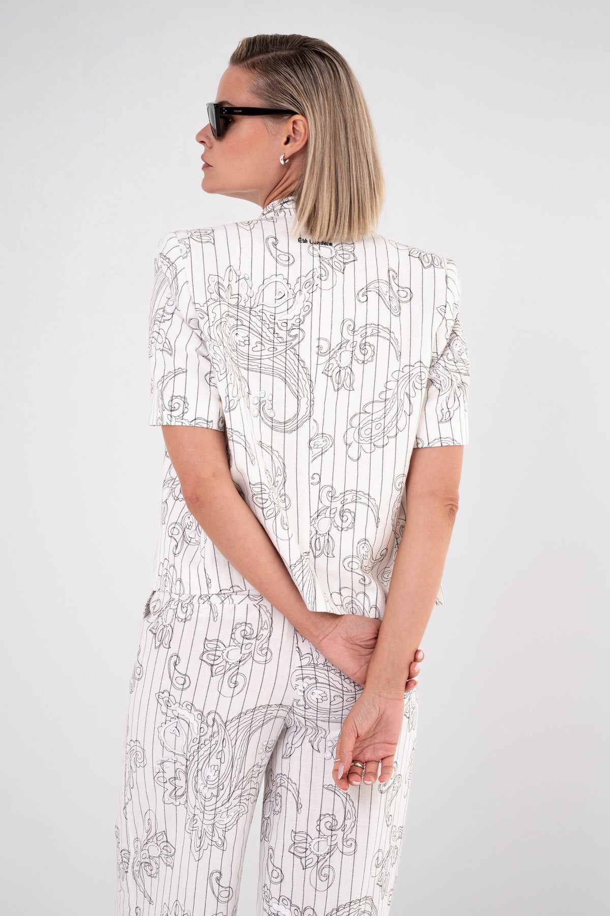Zwarte Paisley jas van Maicazz & Zizo met gedetailleerd patroon en knoopsluiting, gedragen door een model.