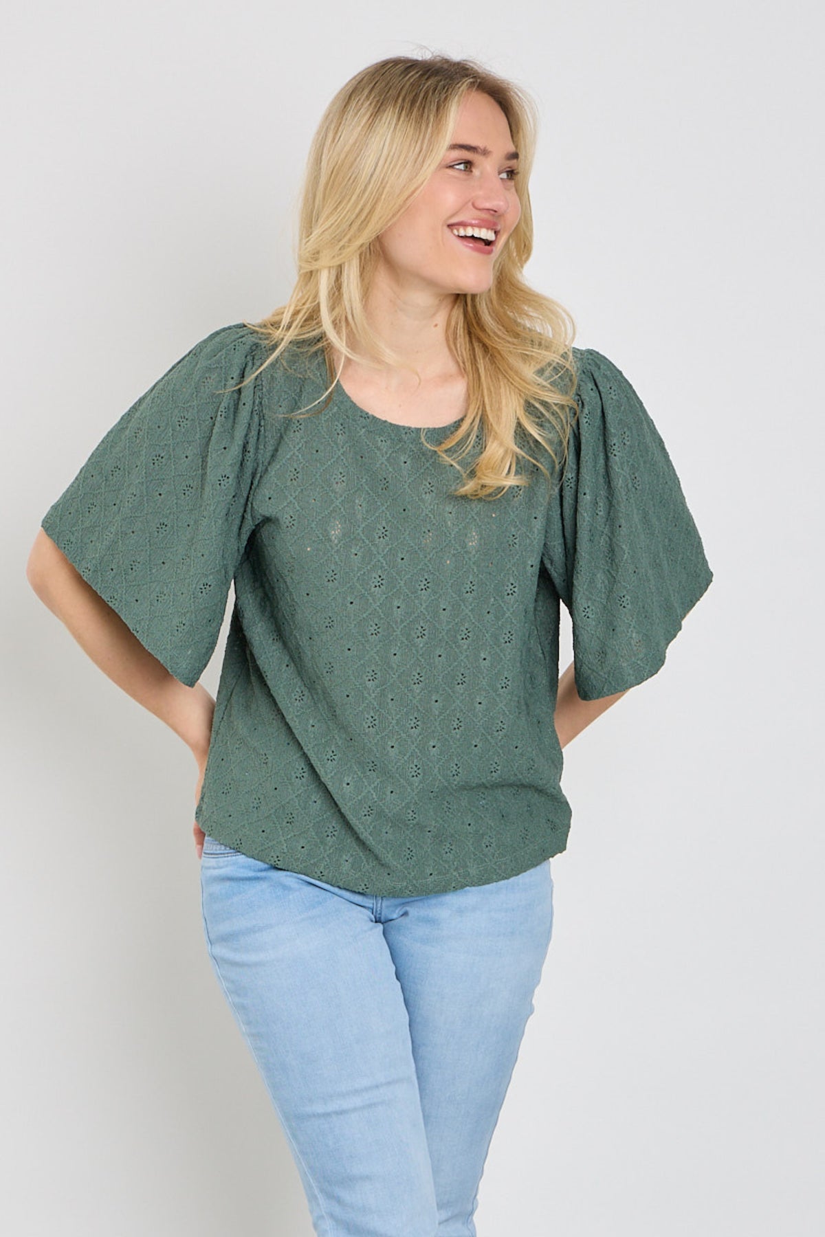 Donkere groene blouse Fqkiona van Freequent met lange mouwen en zachte stof, liggend op een witte achtergrond.