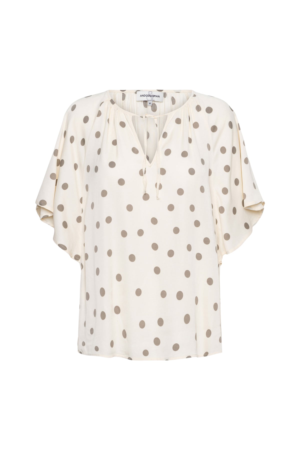 Lichte khaki top Axelle Dot van &Co woman met vanillekleurige details, gedragen door een model.