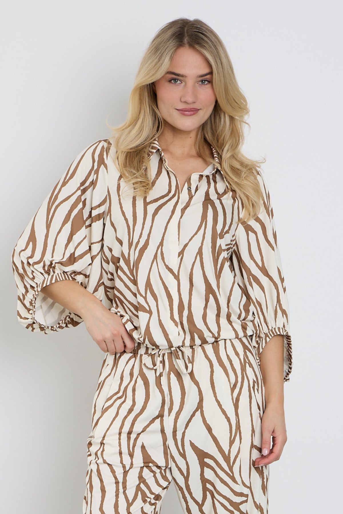 K-design blouse met uniek design en details, modieus en elegant, gedragen door een model.