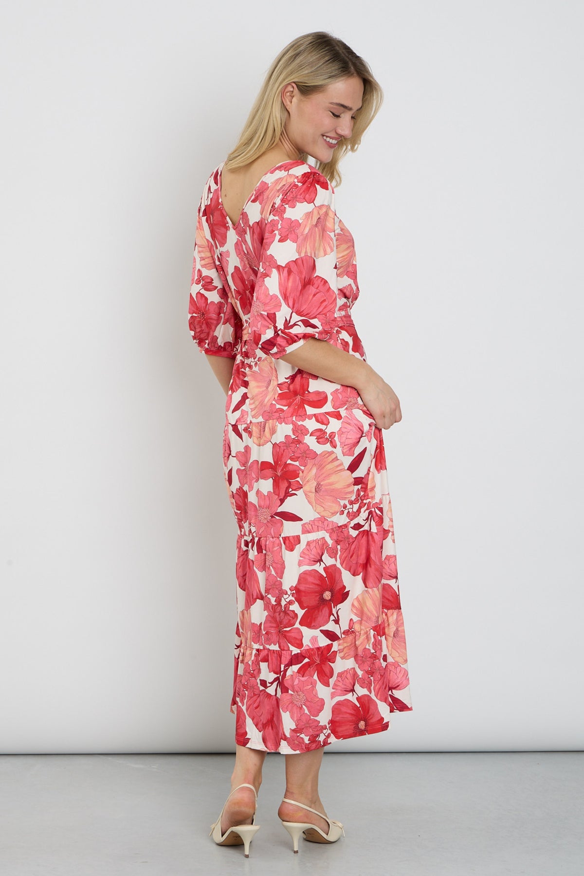 Lange maxi jurk met opvallend ontwerp van K-design, elegante pasvorm en kleurrijk patroon, gedragen door een model.