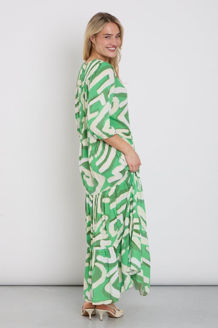 Langwerpige maxi jurk met kleurrijk design van K-design, vloeiend vallend en geschikt voor casual of feestelijke gelegenheden.