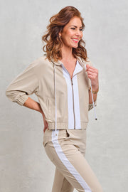 Zoso Travel Jacket Roos Sand 262, lichte reisjas met capuchon en zakken, gedragen door model in buitenomgeving.
