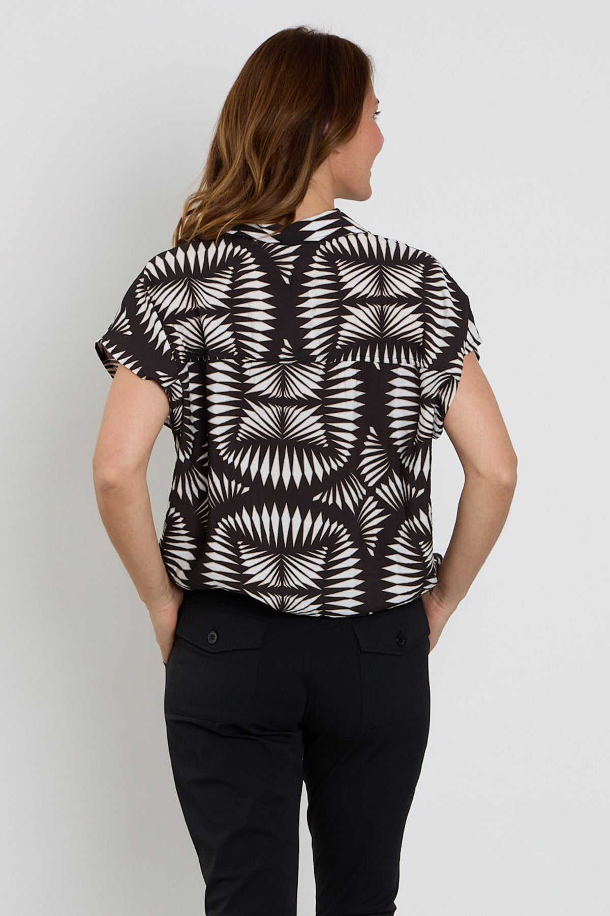 Zoso blouse Melanie zwart Sand 263 met V-hals en lange mouwen, gedragen door een model op een witte achtergrond.