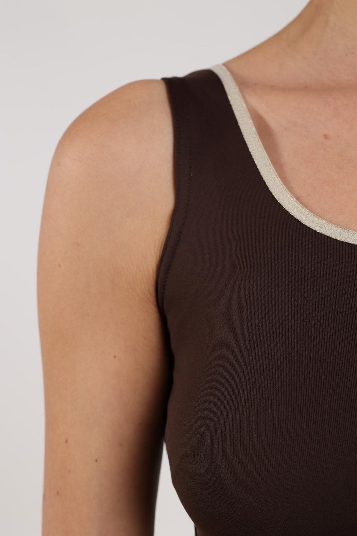 Donkerbruine Nukus singlet Juba met gouden details, close-up van de stof en ontwerp, voor dames.