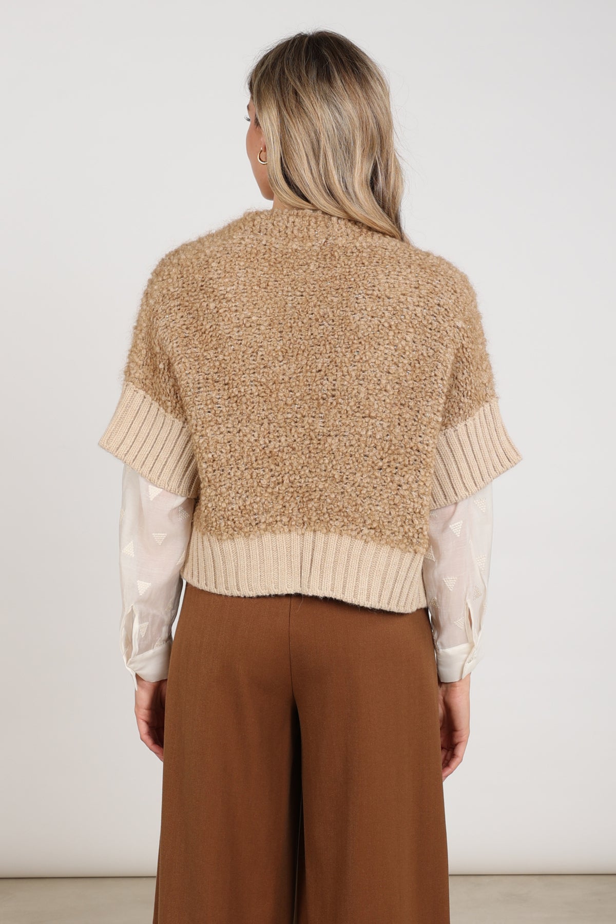 Nukus Bell Toffee vest met verstelbare band en stijlvolle uitstraling, gedragen door model voor casual draagstijl.