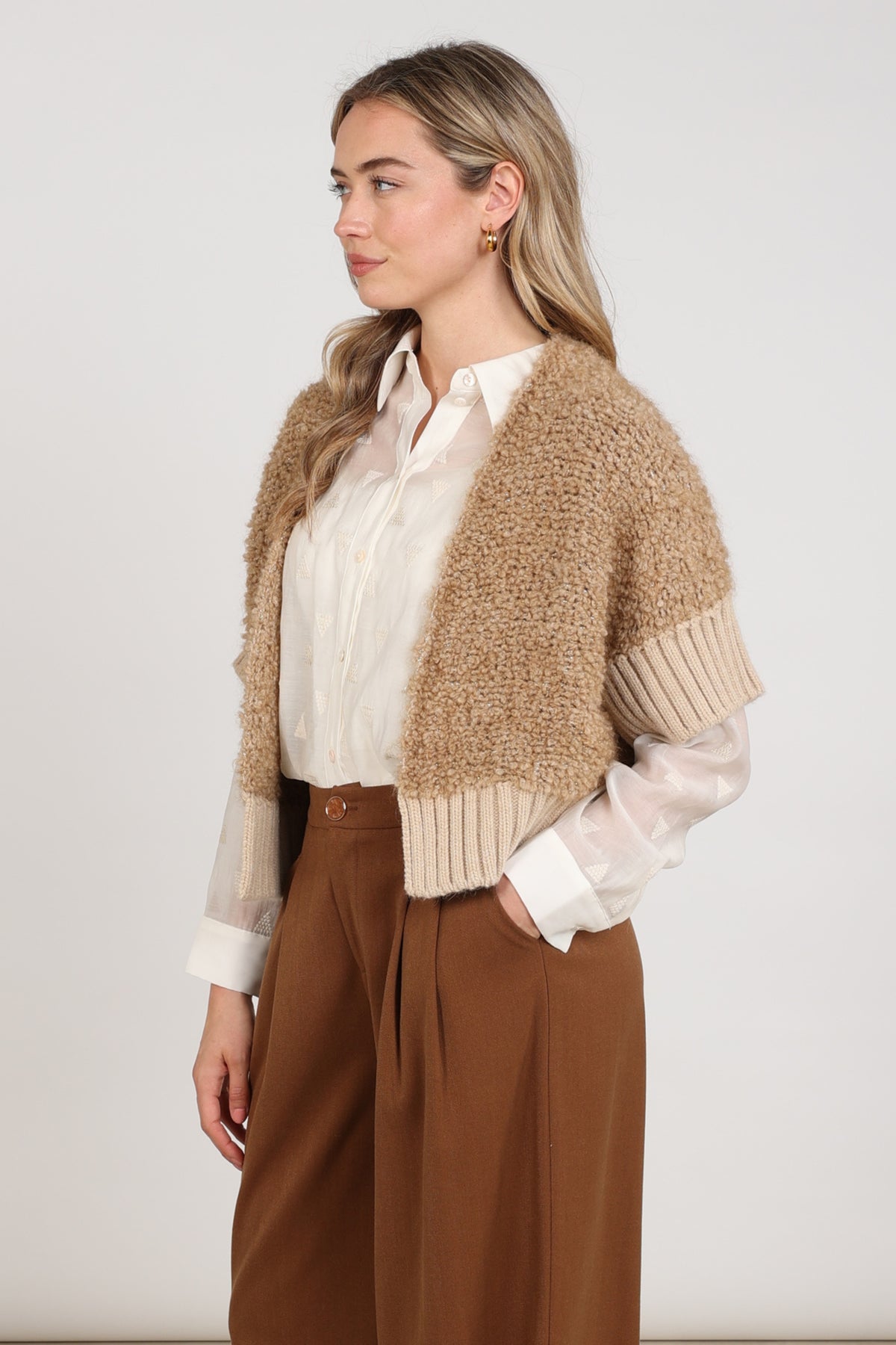 Nukus vest Bell Toffee NKF05032 in bruin met ronde hals en zachte stof, gedragen door een model op een lichte achtergrond.
