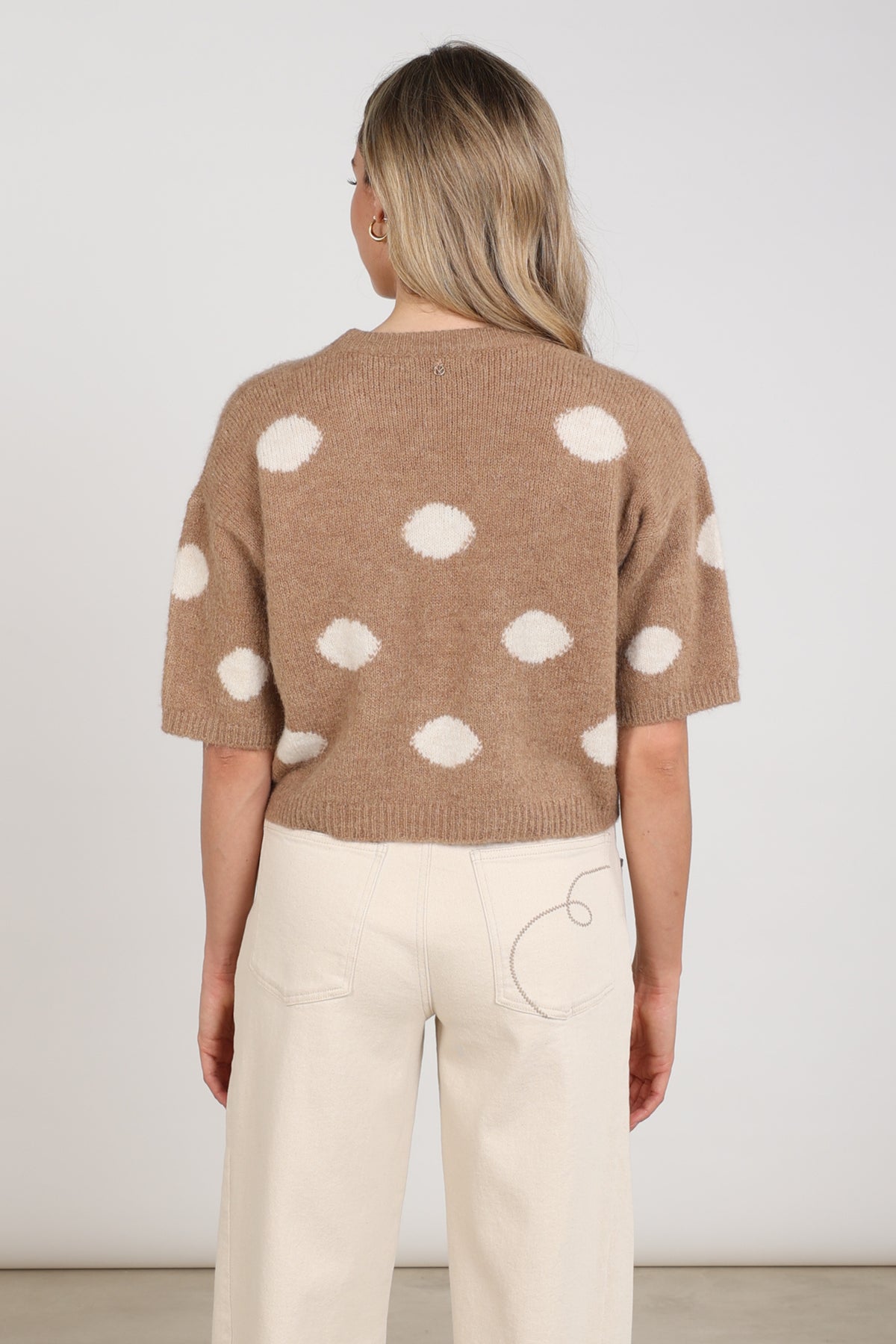 Taupe Nukus Trui Lara Dots met ronde hals en lange mouwen, close-up van zachte, gebreide textuur.