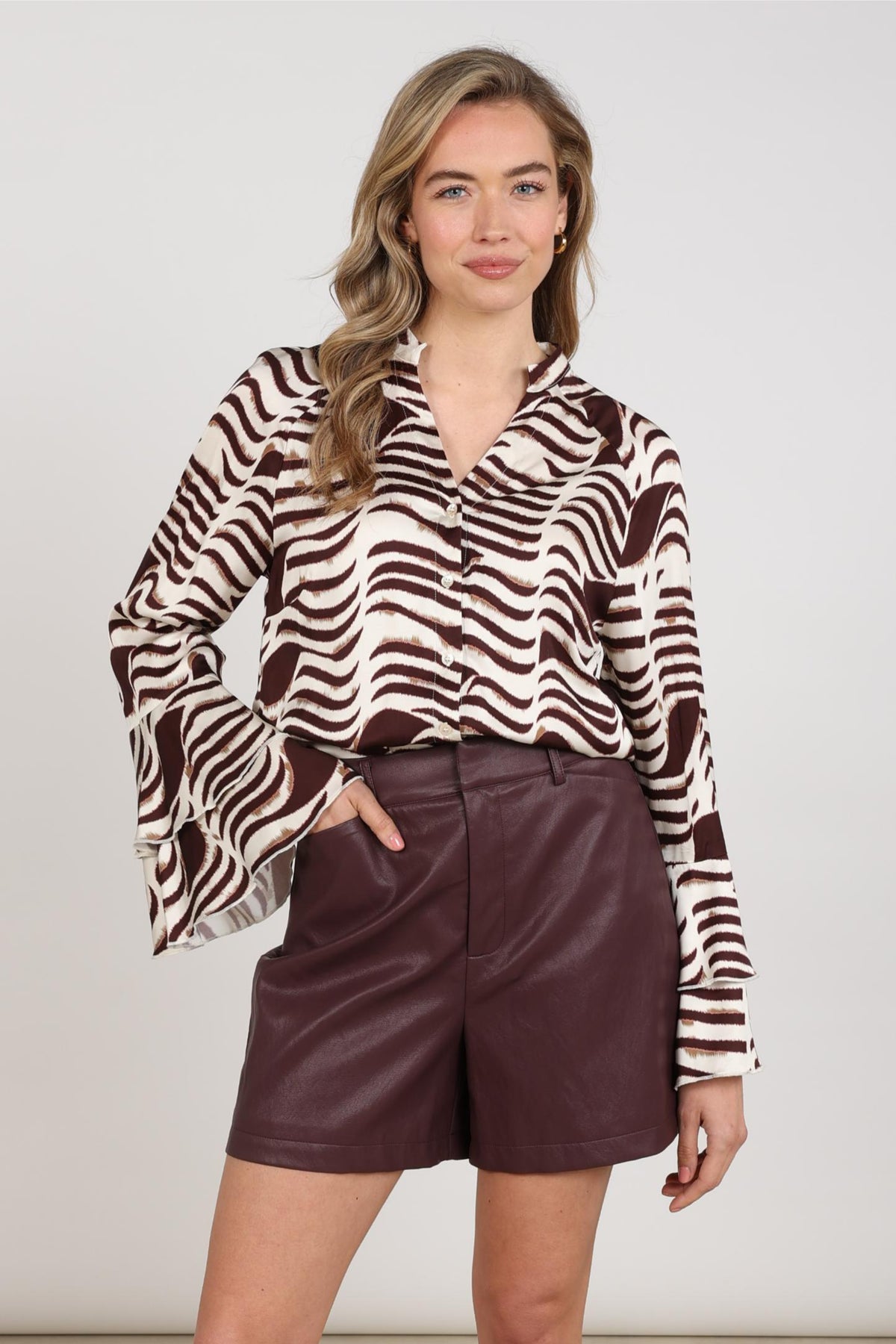 Zwarte en witte zebraprint blouse van Nukus, model April Zebra Offwhite Cherry, met losvallende pasvorm en lange mouwen.