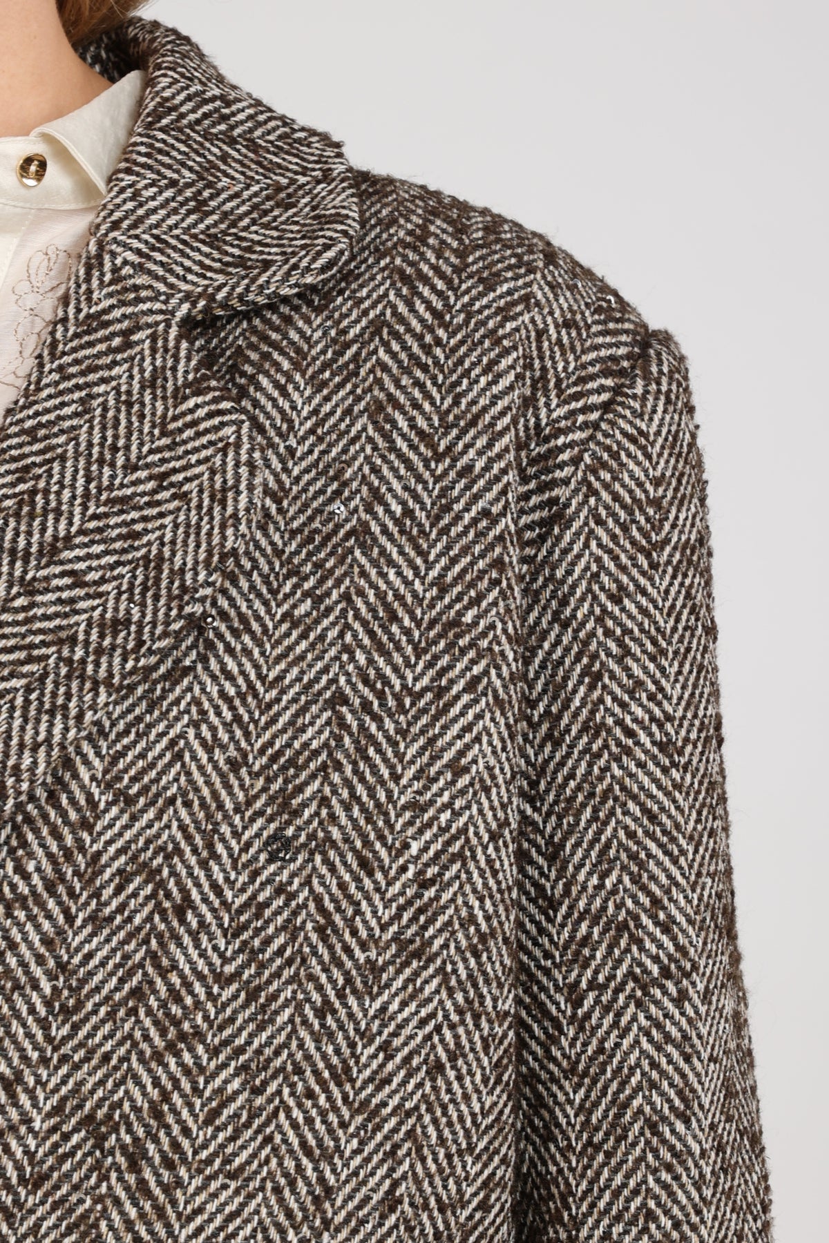 Donkere chocolade Daphne Herringbone jas van Nukus met vintage patroon en stijlvolle uitstraling, gedragen door model.